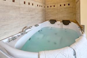 克卢奇堡Sommer Residence Hotel&Spa的带浴缸的浴室,设有木墙