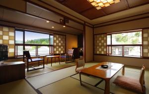 藏王温泉Zao Onsen Omiya Ryokan的客厅配有桌椅和窗户。