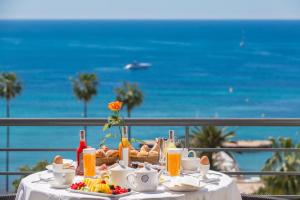 戛纳雄伟戛纳巴里耶尔酒店的一张带食物的桌子,享有海景