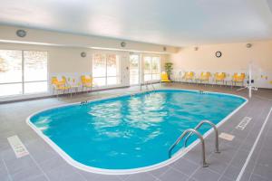 昆西昆西万豪费尔菲尔德客栈&套房酒店的医院里的一个游泳池,配有橙色椅子