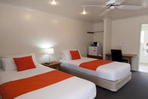 吉斯伯恩AhiKaa Gisborne Motel的酒店客房配有两张床和吊扇。