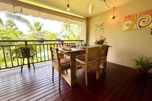 普纳奥亚Vaiava Beach Carlton- Tahiti - beachfront luxury residence & pool - 4 pers的阳台的用餐室配有桌椅