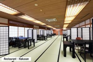 小松市Manten no Tsujinoya的用餐室设有桌椅和窗户。