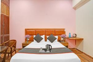 大诺伊达OYO Flagship 74435 Hotel Sharma的酒店客房配有一张床铺和一张桌子。
