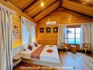 仙本那Singamata Resort的卧室配有一张床铺,位于带木墙的房间内