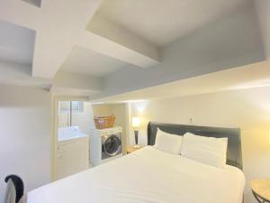 华盛顿COMFY Basement Home 2 Bdrm1Den 3Queen Beds的一间卧室配有一张床和一台洗衣机