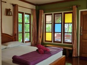 席昌岛Hello Sichang Bungalow的一间卧室设有两张带紫色床单和窗户的床。