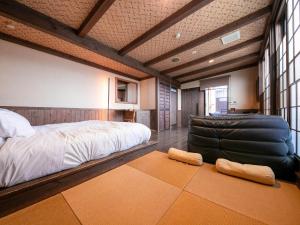MiyajiTsuruya / Vacation STAY 59065的一间卧室配有一张大床和一张皮椅