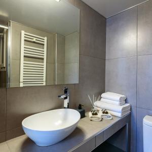 雅典阿莫尼克公寓的浴室设有大型白色水槽和镜子
