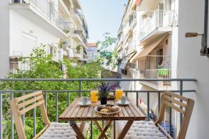 雅典阿莫尼克公寓的阳台配有桌椅。