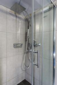 雅典阿莫尼克公寓的浴室里设有玻璃门淋浴