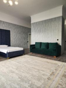 博罗沃耶Hotel Inju的客厅配有绿色沙发和床。