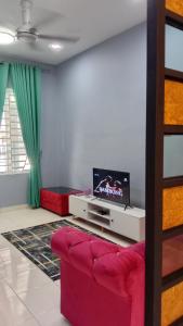 加央MAS'homestay perlis的客厅配有红色沙发和电视