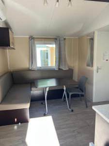 拉罗克当泰龙Mobil-Home des Iscles的小房间设有书桌和窗户