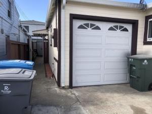 圣布鲁诺SFO New Comfortable Studio的车库,设有白色的车库门和垃圾桶