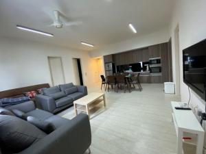 峇都丁宜By The Sea - UBTS SMART ENTERPRISE的客厅配有沙发和桌子