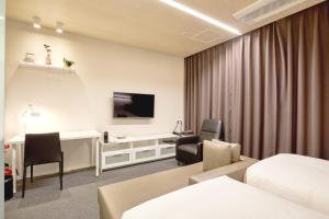 昌原市Grand City Hotel Changwon的配有一张床和一张书桌的酒店客房