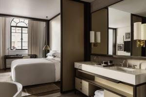 悉尼Capella Sydney的一间卧室配有床、水槽和镜子