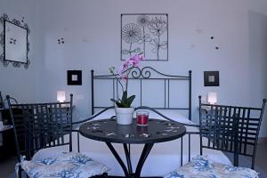 斯培西亚拉卡萨帝加布里埃拉酒店的一张桌子,上面有花瓶,有两把椅子