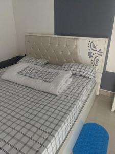 RubavuIgnite guest and apartment的一张带灰色和白色床垫及蓝色地毯的床