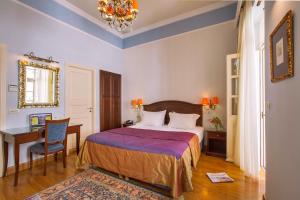 纳夫普利翁艾特马酒店 的一间卧室配有一张床、一张桌子和一把椅子