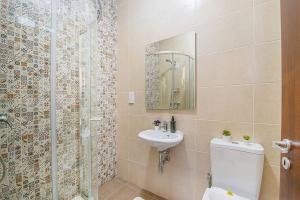 马萨尔福恩Hillock Residence Apartments的带淋浴、卫生间和盥洗盆的浴室