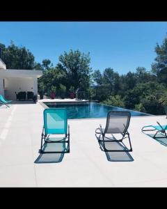Flassans-sur-IssolePetit paradis sur golf的游泳池旁的三把椅子