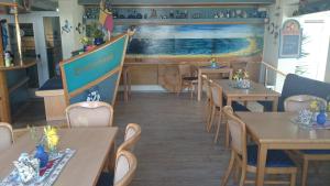 瓦尔内明德Landhotel Ostseetraum & Fewo的餐厅设有木桌、椅子和柜台