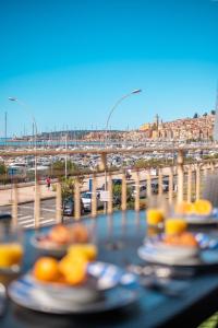 芒通La Grande Palmeraie - Spacieux studio avec vue mer, terrasse, port de Garavan的一张带食物盘的桌子,享有高速公路的景色