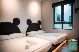 淡文JOMSTAY Sunway Onsen Suites Ipoh - Lost World of Tambun Ipoh Waterpark的带窗户的客房内的两张床