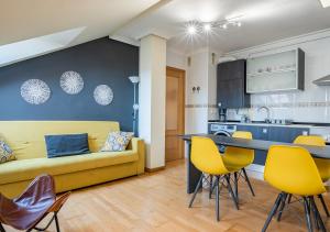 坎加斯-德奥尼斯Apartamento Irene céntrico con Wifi y parking coche tamaño medio Cangas de Onís的一间带黄色沙发的客厅和一间厨房