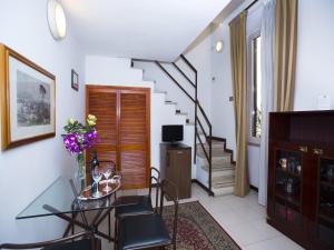 罗马塔索尼公寓别墅酒店的一间带玻璃桌和楼梯的客厅