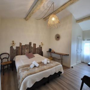 MontcalmMANADE SAINT LOUIS Mas de La Paix的一间卧室配有一张大床和一个吊灯。