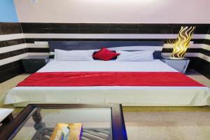 JhājharSuper OYO Riverview Resort And Restaurant的一间卧室配有一张带红色毯子的大床