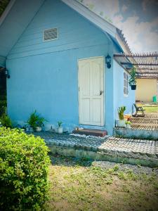 拜县Pai Casita的蓝色的房子,有白色的门和一些植物