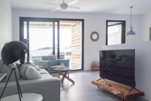 厄尔·波索·德·洛斯·弗莱尔Terrazas Faro 18的带沙发和平面电视的客厅