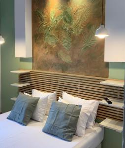 凯法利尼亚岛Katarina Apartments的一间卧室配有带枕头的床铺和绘画