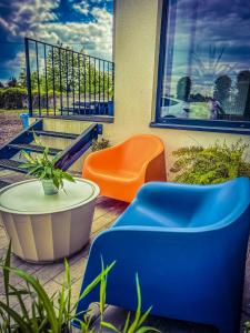 格利维采Apartamenty Gliwice Staromiejska 65的阳台上摆放着橙色和蓝色的椅子