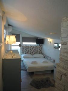 布雷拉Riva Brela SP-small loft的一间卧室配有一张床和一张桌子上的台灯