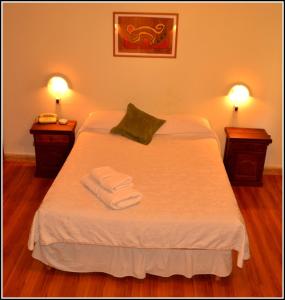圣拉斐尔艾拉斯酒店的一间卧室配有一张床,上面有两条毛巾