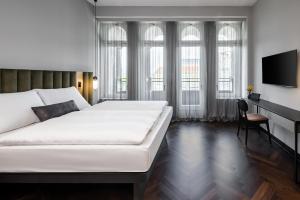 莱比锡AMANO Home Leipzig的卧室配有一张白色大床和一张书桌