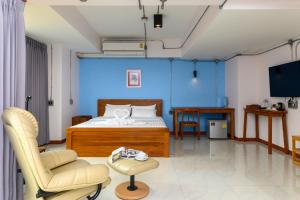 清迈清迈那巴雅查酒店的卧室拥有蓝色的墙壁,配有一张床和椅子