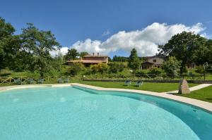 RoccalbegnaMelograno的一个带椅子的大型游泳池和一个背景房子