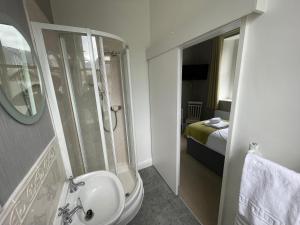 凯西克The Capsule in Keswick的一间带水槽和淋浴的浴室以及一张床