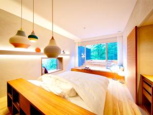 嬉野市奥武雄温泉　風の森的一间卧室配有一张床、一个窗户和吊灯