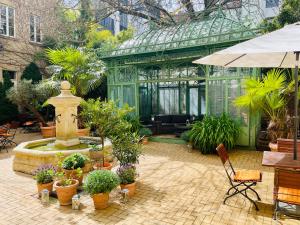 柏林花园生活 - 精品酒店的一座温室,里面装有喷泉和盆栽植物