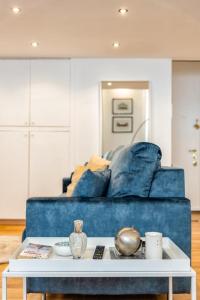 都灵Loft Crocetta的客厅配有蓝色的沙发和桌子