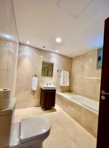 拉纳卡Aphrodite Plaza的浴室配有卫生间、浴缸和水槽。