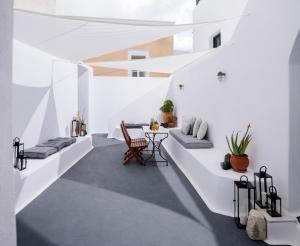 费拉Firalia, Casa in Rock Suites的一间拥有白色墙壁和桌椅的房间