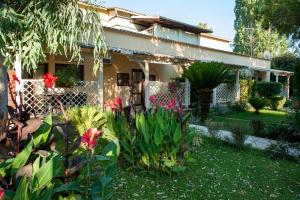 古维亚Spiti Prifti Apartments的庭院里带花卉的花园的房子